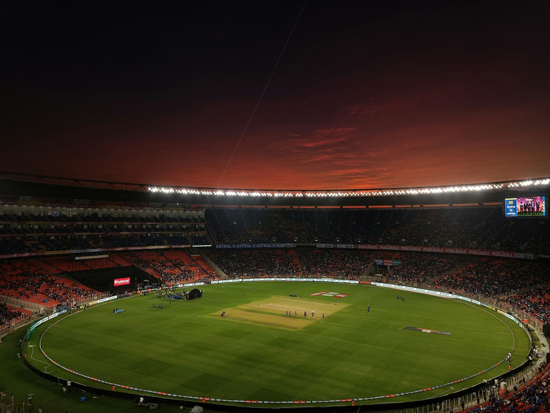 Cricket stadium under a red evening sky